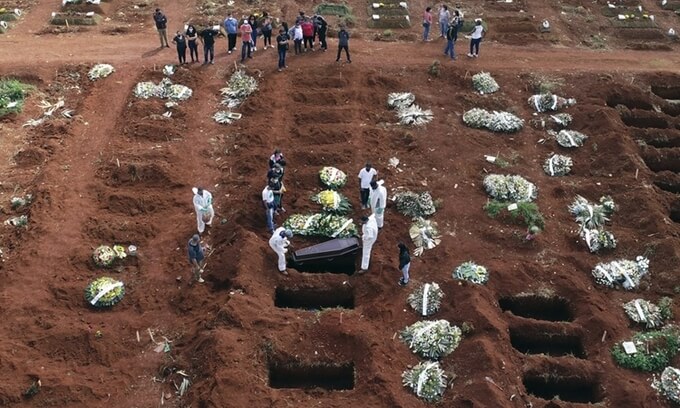 Nhân viên mặc đồ bảo hộ chôn cất thi thể bệnh nhân tử vong do Covid-19 ở Sao Paulo, Brazil