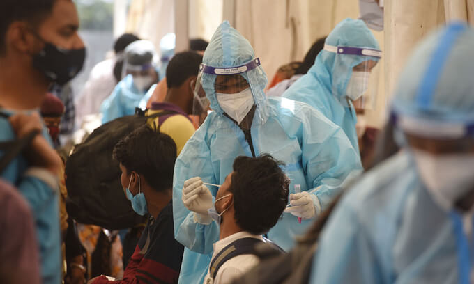 Nhân viên y tế lấy mẫu xét nghiệm nCoV tại một bến xe buýt ở New Delhi